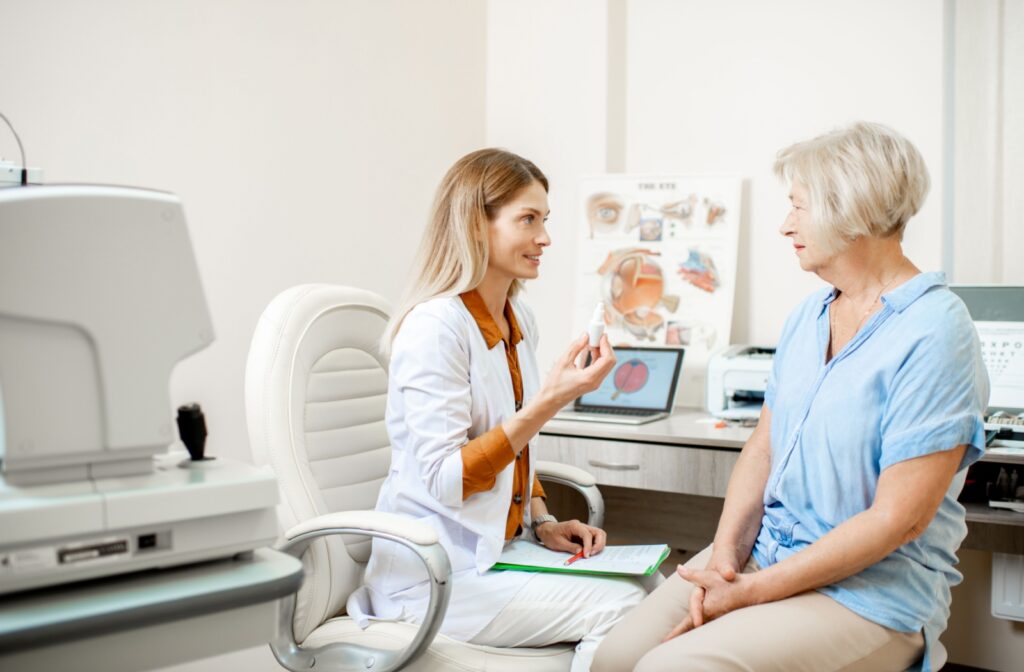 A senior sits in a chair at the eye doctors and talks to an optometrist