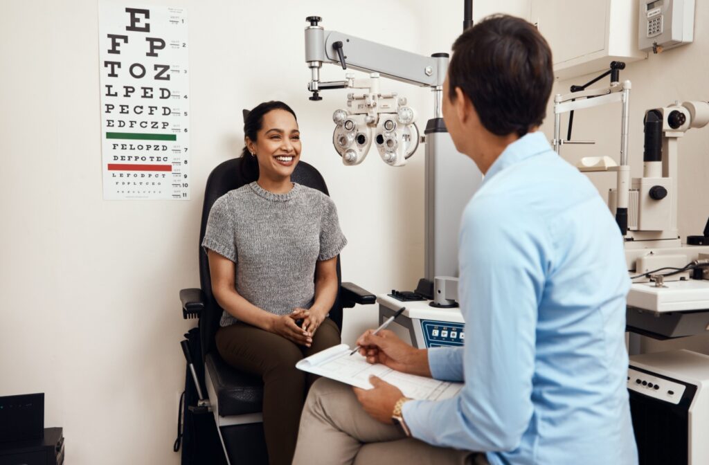 A person sits in a chair smiling while talking to an optometrist about dry eye treatment